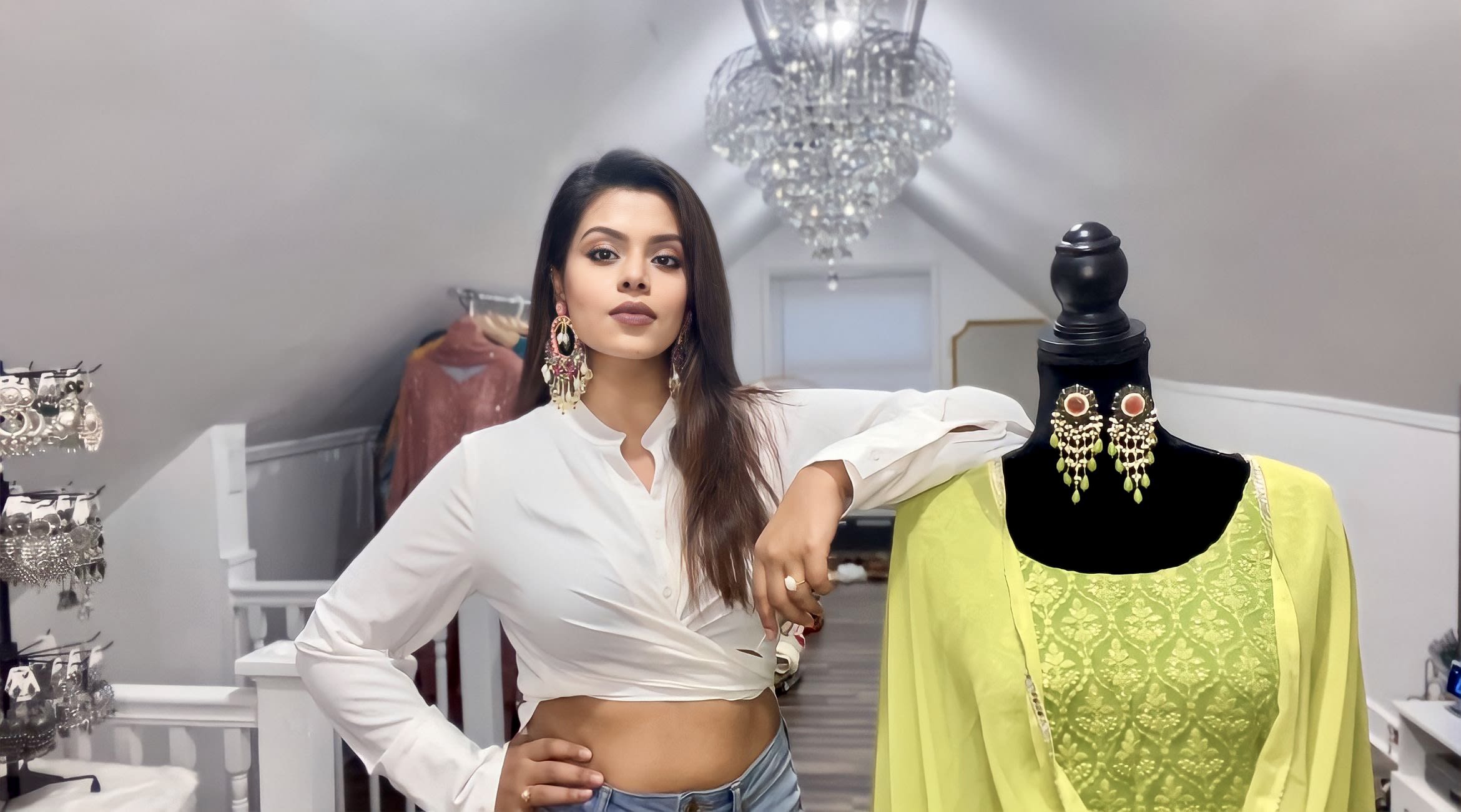 Aaizaa's founder Sharmin Khan stands in a powerful pose looking at the camera next to a mannequin wearing a beautifully designed yellow traditional Indian garment and earrings. 