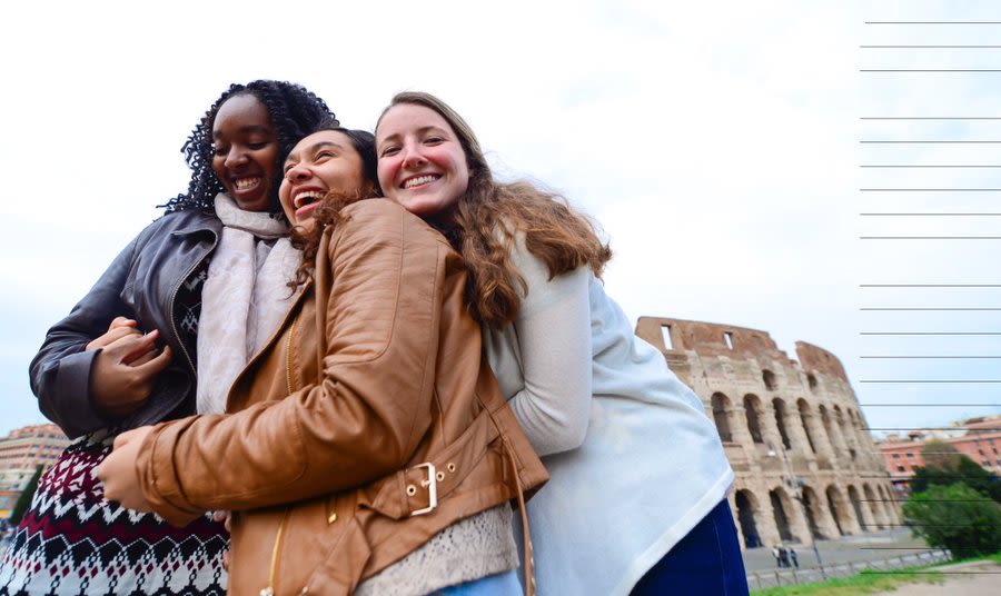 Three girls hugging in front of the colosseum 