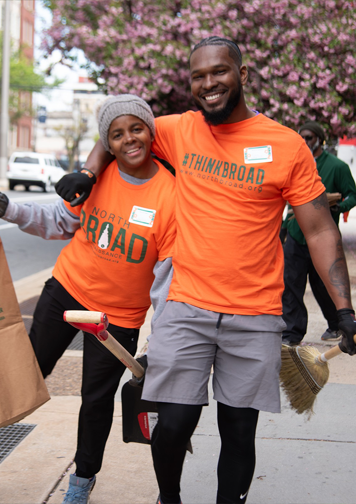Volunteers in orange smiling