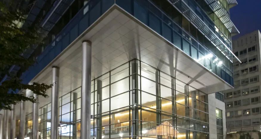 an empty theater with red seats and a projector screen